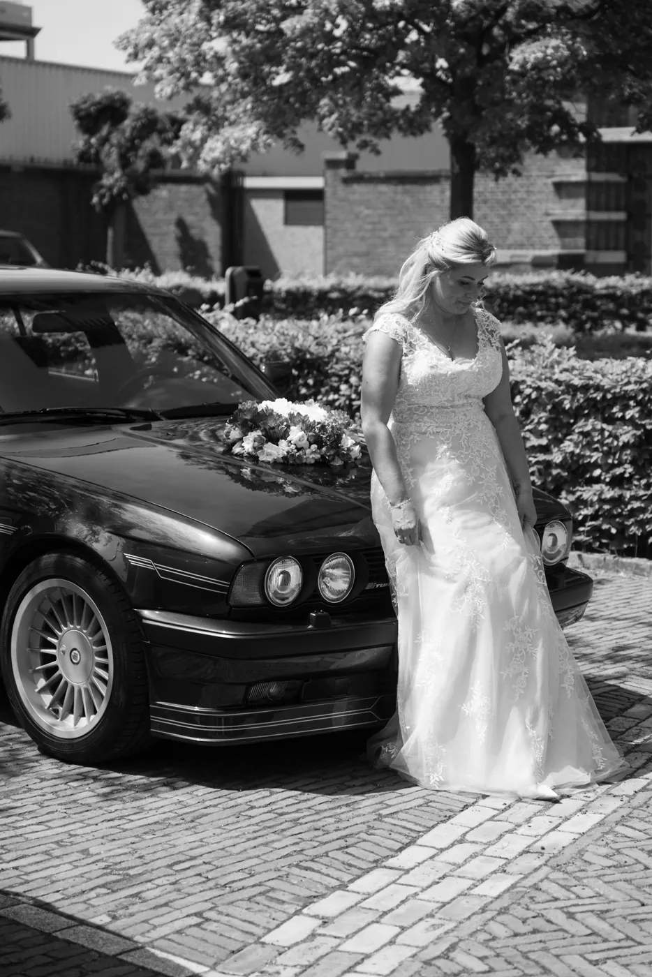 Bruid bij een klassieke auto op de trouwdag